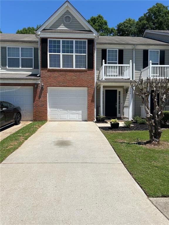 View of front of home with a garage and a balcony