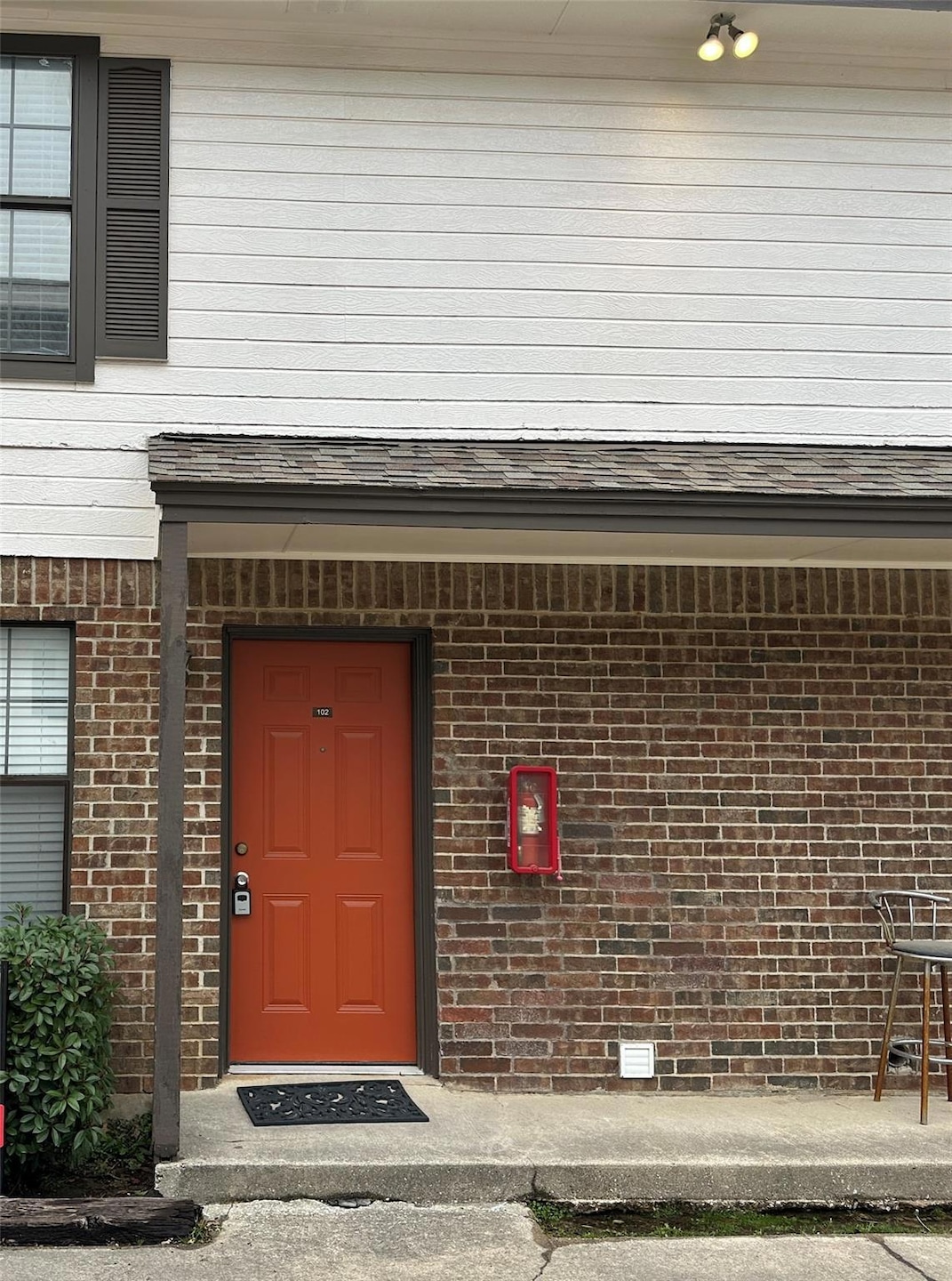 Property entrance featuring a shingled roof and br