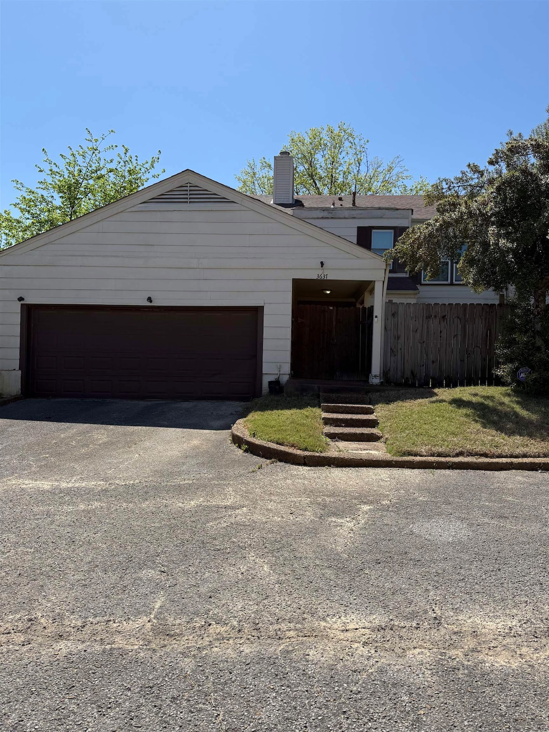View of front of home featuring a garage, a chimne