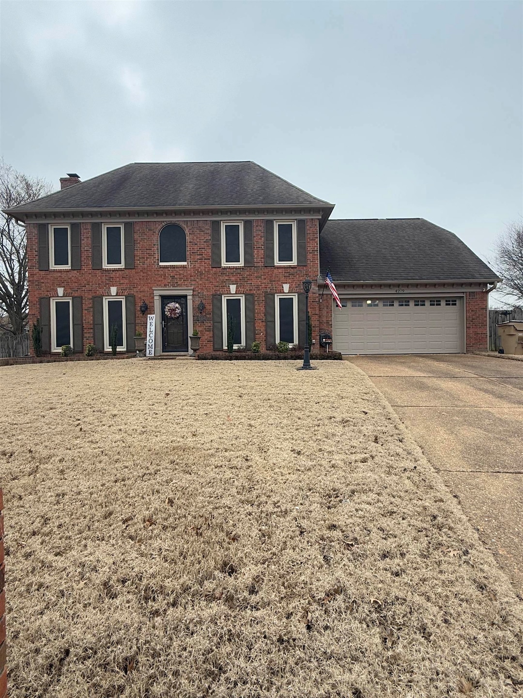 Colonial-style house featuring a garage, brick sid