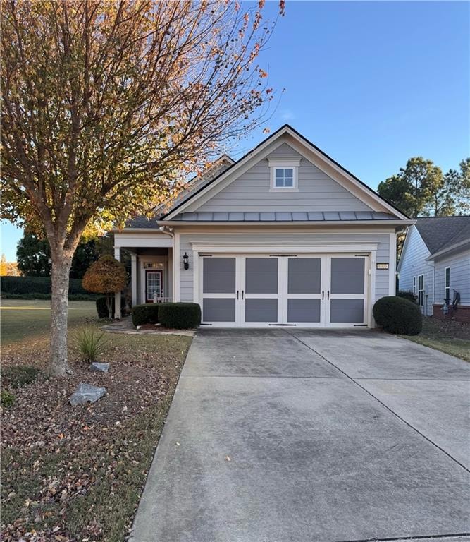 View of front of home featuring concrete driveway and a garage