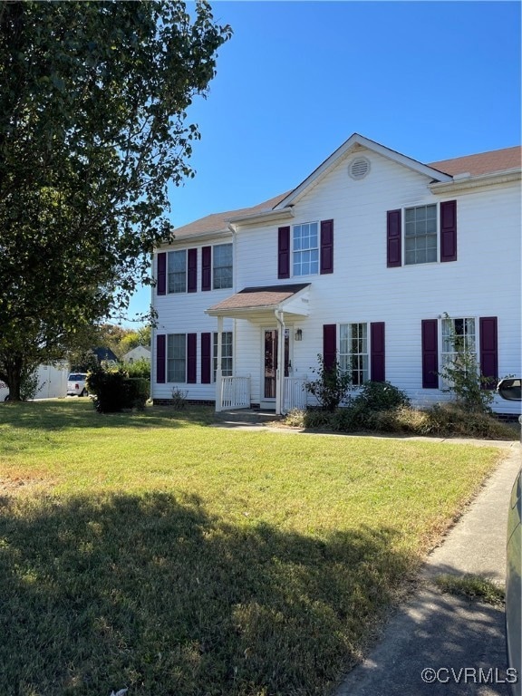 Colonial-style house featuring a front lawn