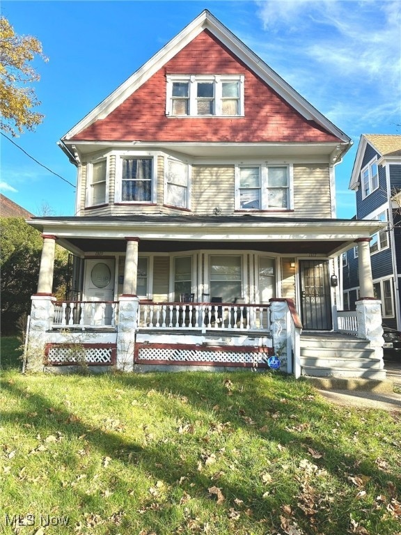 View of front of house with covered porch and a front yard