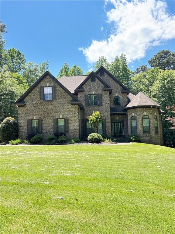 French provincial home with brick siding and a fro