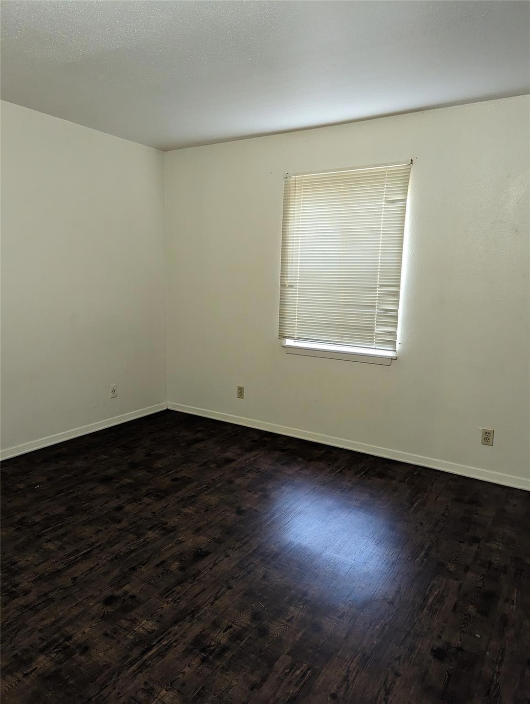 Unfurnished room with dark hardwood / wood-style f