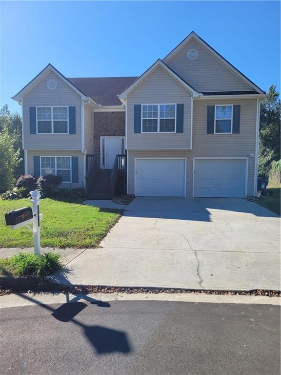 Bi-level home with a garage and a front lawn