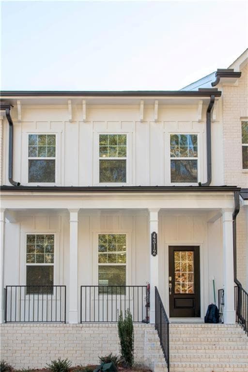 View of front of property with board and batten siding and covered porch