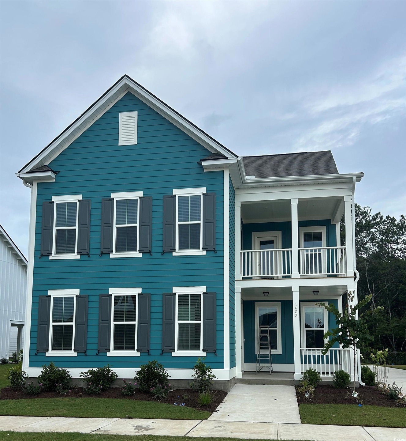 View of front of home featuring a balcony and covered porch