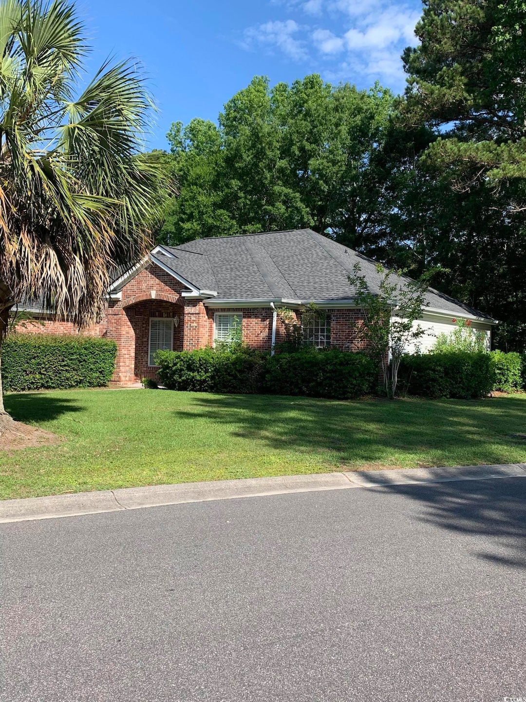 Ranch-style home featuring brick siding and a front lawn