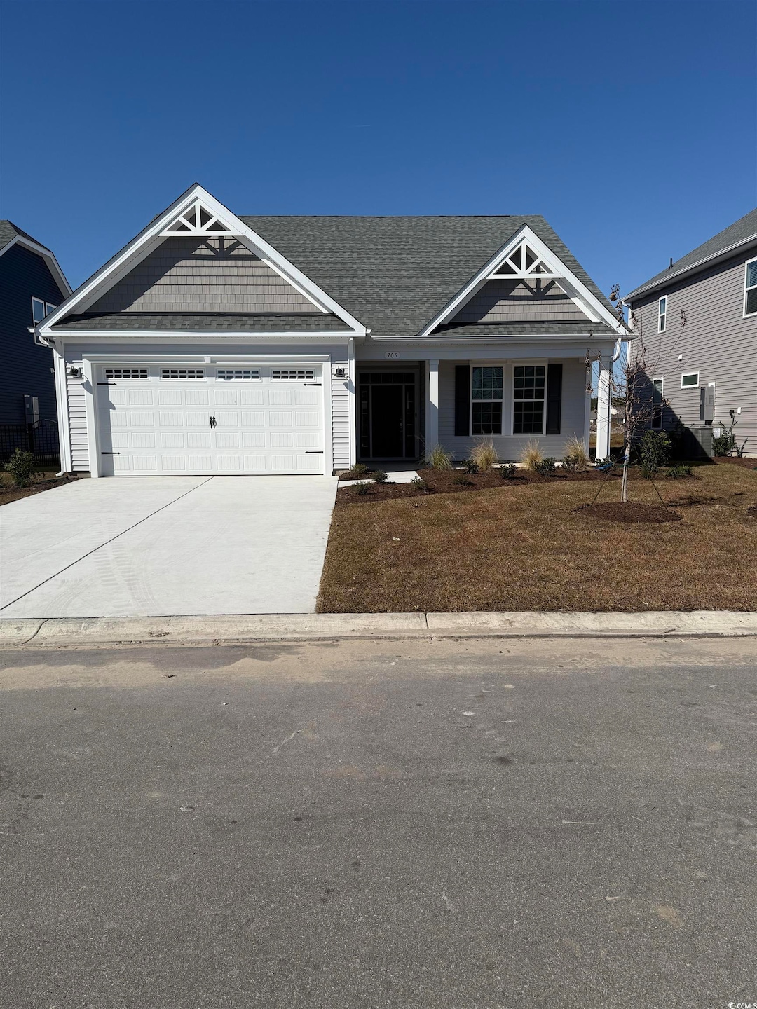 View of front of property with concrete driveway, a garage, and a porch