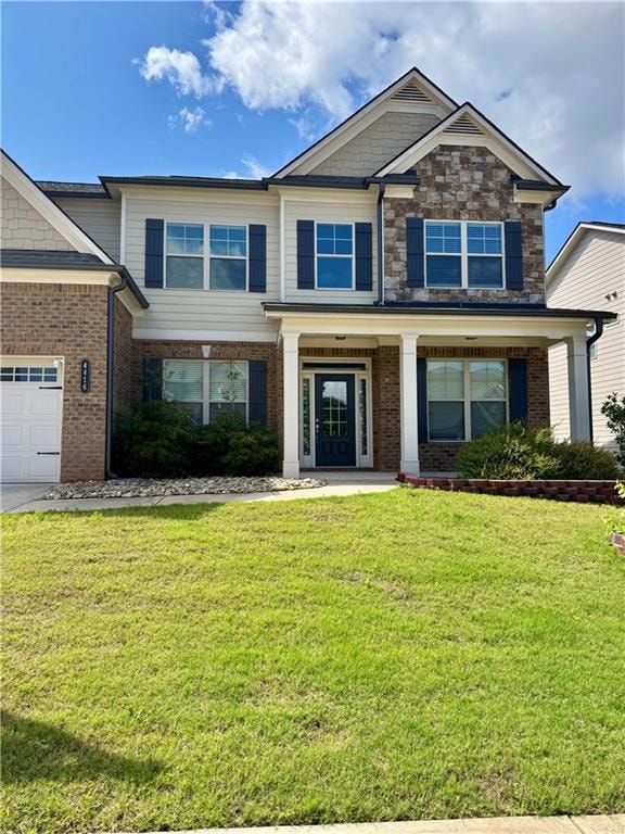 View of front of property with a front lawn, brick siding, and a garage