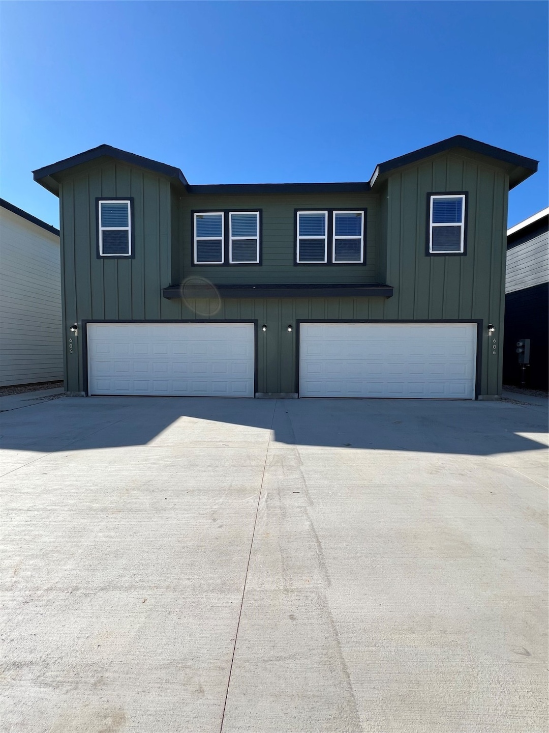 View of front of home featuring board and batten siding, an attached garage, and driveway