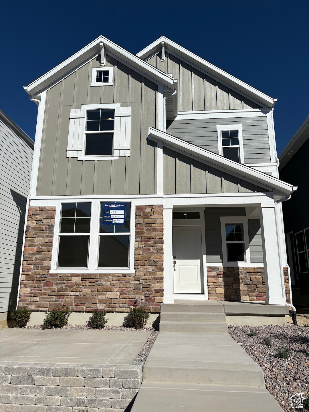View of front of house featuring board and batten siding, stone siding, and a porch