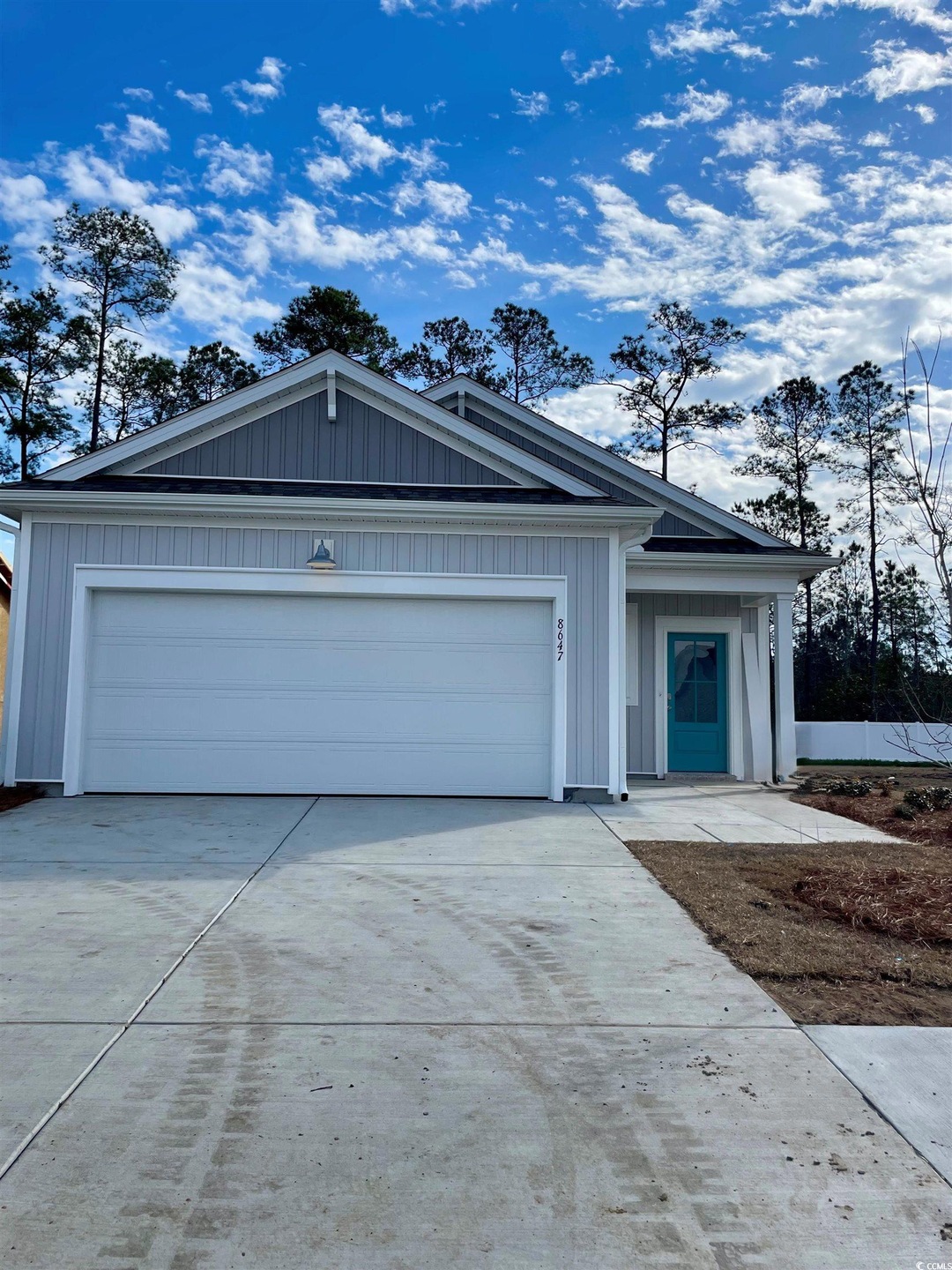 Ranch-style home with driveway, board and batten siding, and a garage