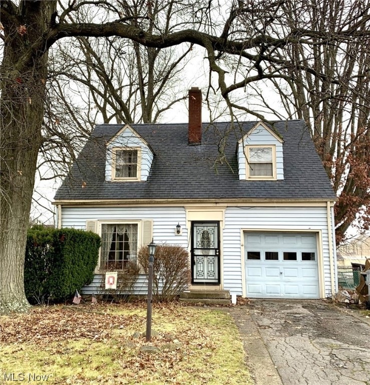 Cape cod-style house featuring a garage