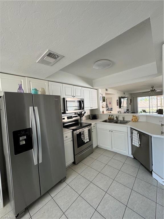 Kitchen featuring white cabinets, range, dishwashi
