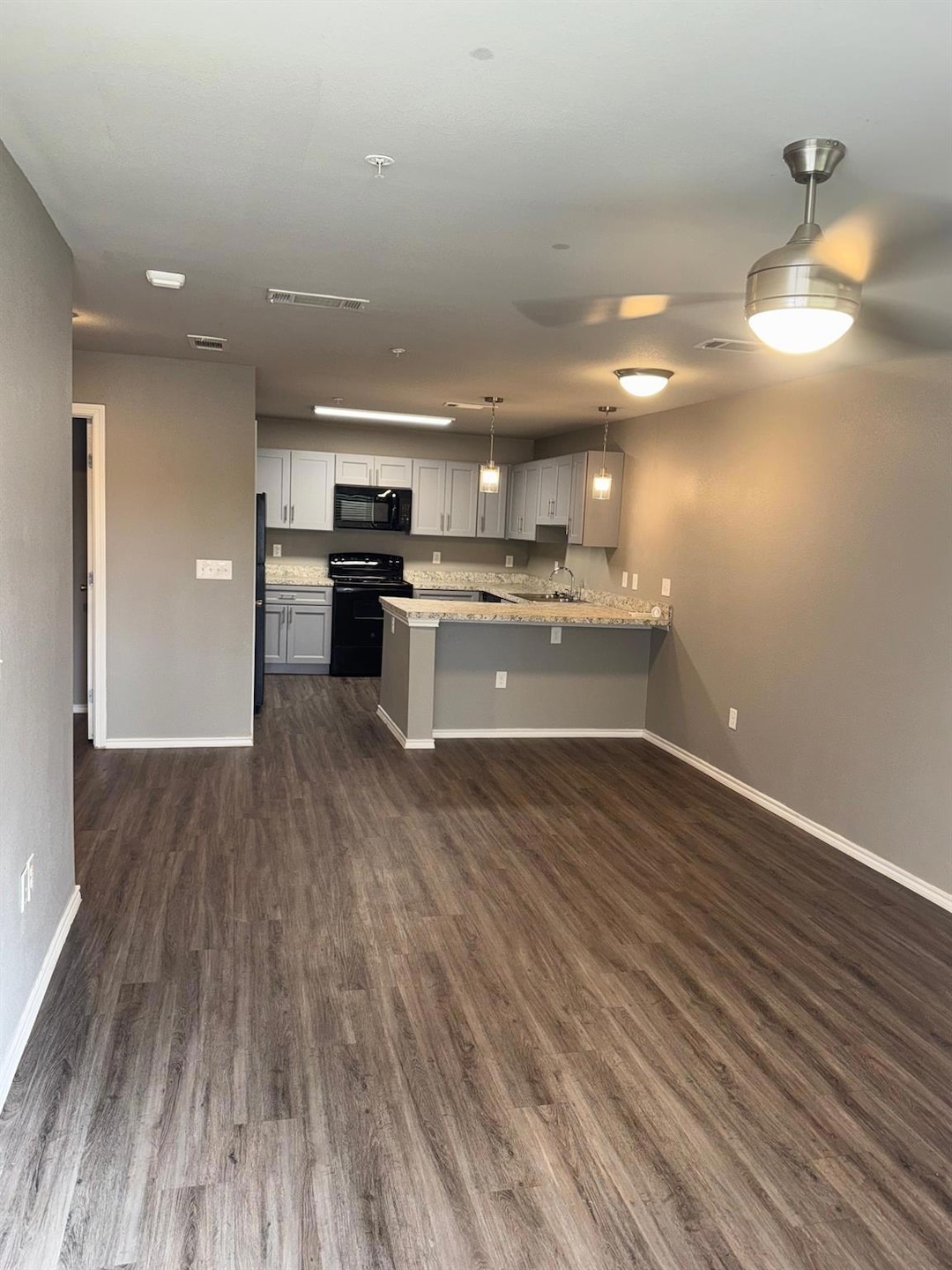 Kitchen featuring a peninsula, baseboards, range, 