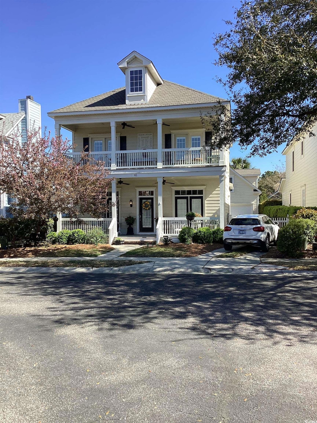 View of front of house featuring a balcony, a porch, and ceiling fan