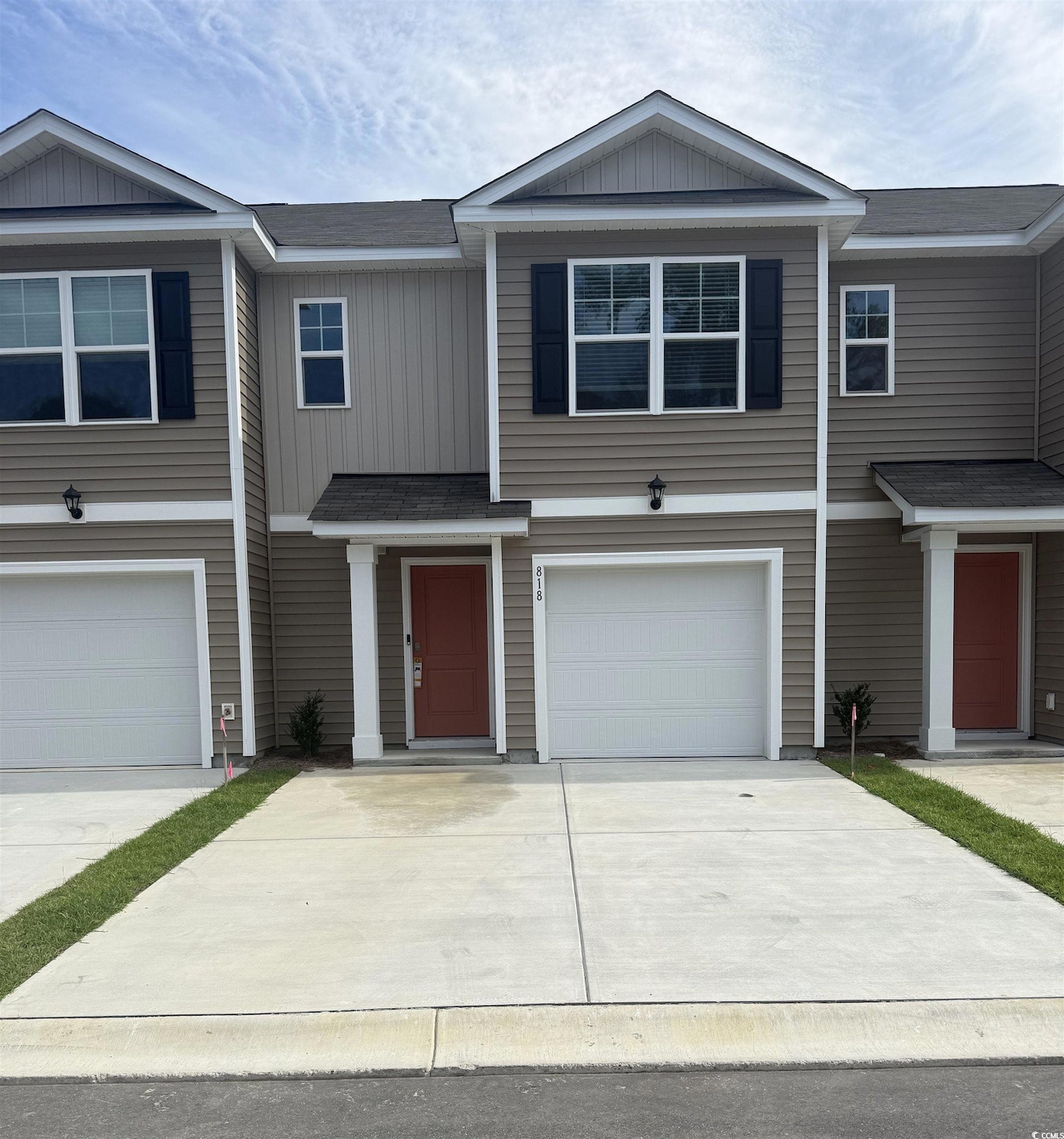 View of front facade featuring an attached garage, board and batten siding, driveway, and a shingled roof