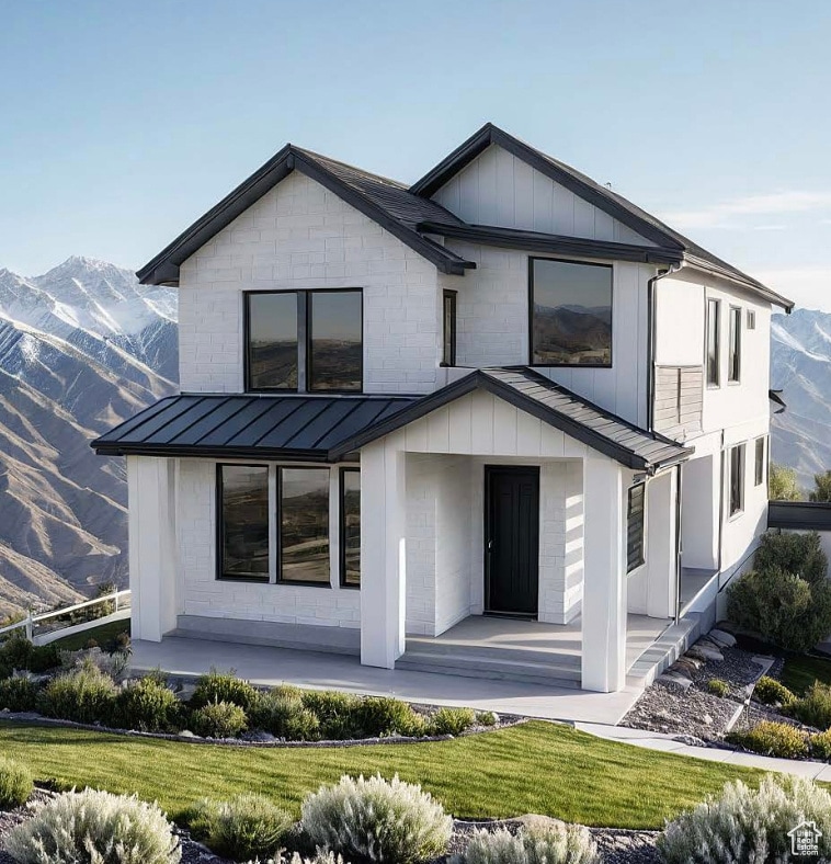 Back of house with a mountain view, a standing seam roof, a metal roof, and a porch