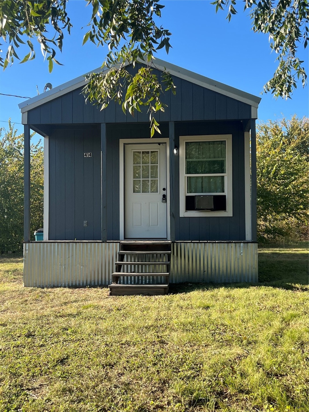 View of front of home with entry steps and a front lawn