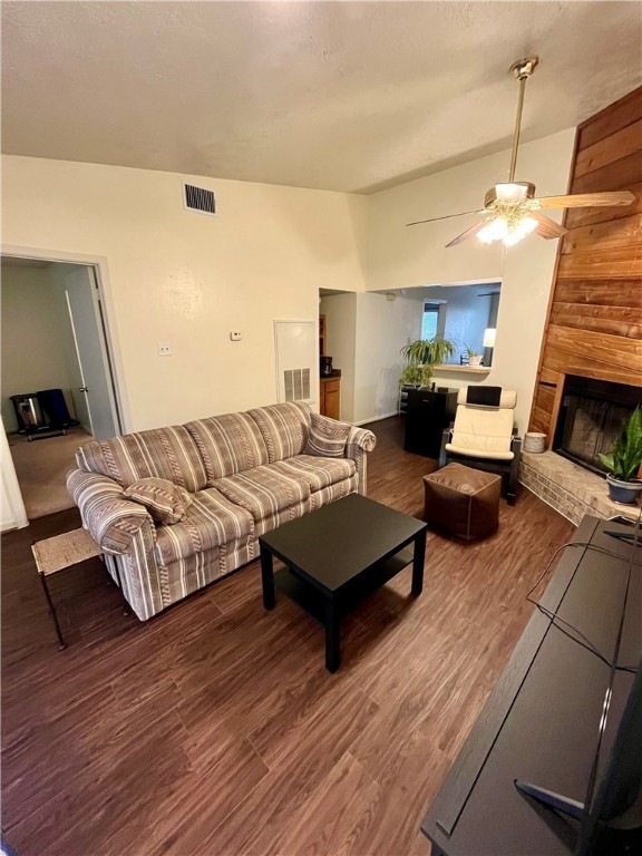 Living room featuring a ceiling fan, a brick firep