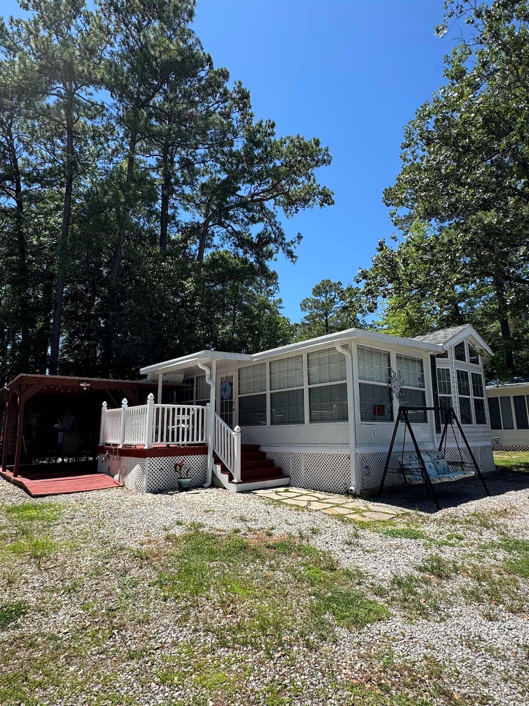 Rear view of house featuring a sunroom and a deck