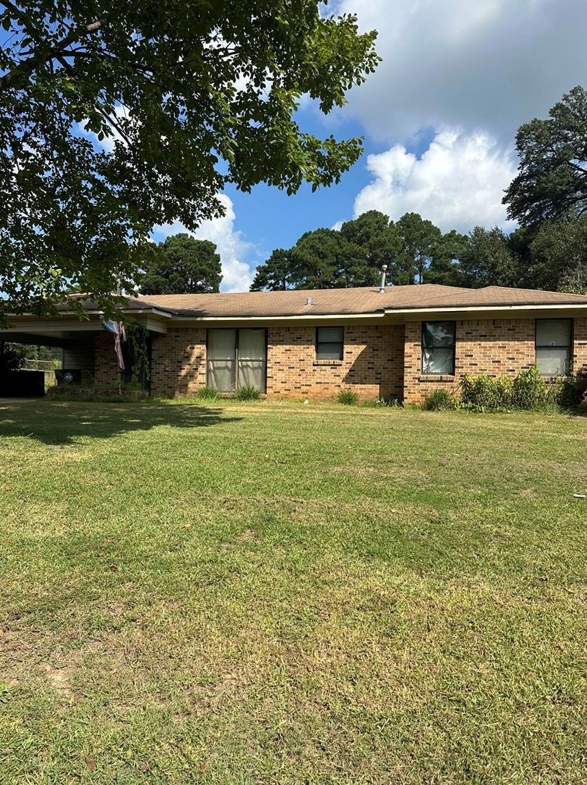 Ranch-style home featuring a front lawn