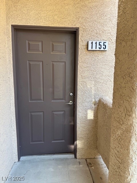 Entrance to property featuring stucco siding