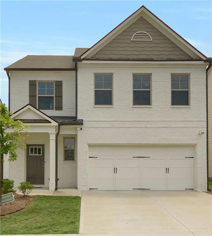 View of front of house with brick siding, concrete driveway, and an attached garage