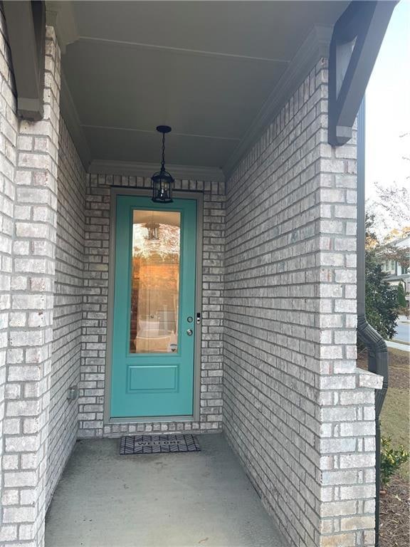 Property entrance with brick siding and covered porch