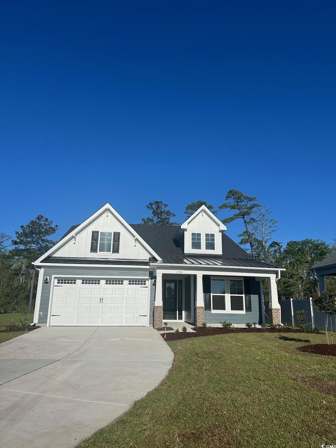 View of front facade with driveway, fence, brick s