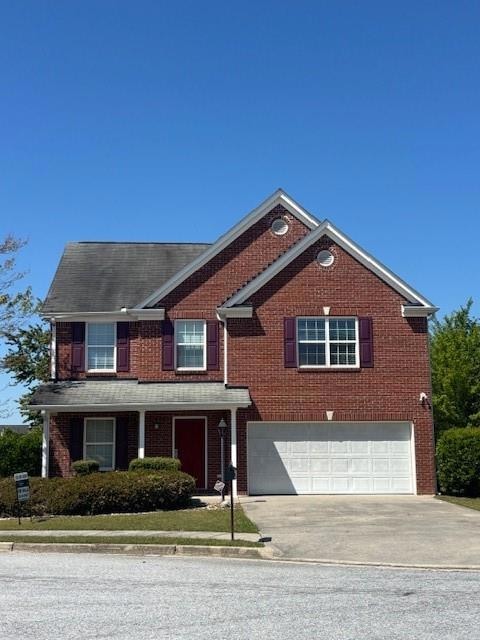 Traditional home featuring brick siding, an attach