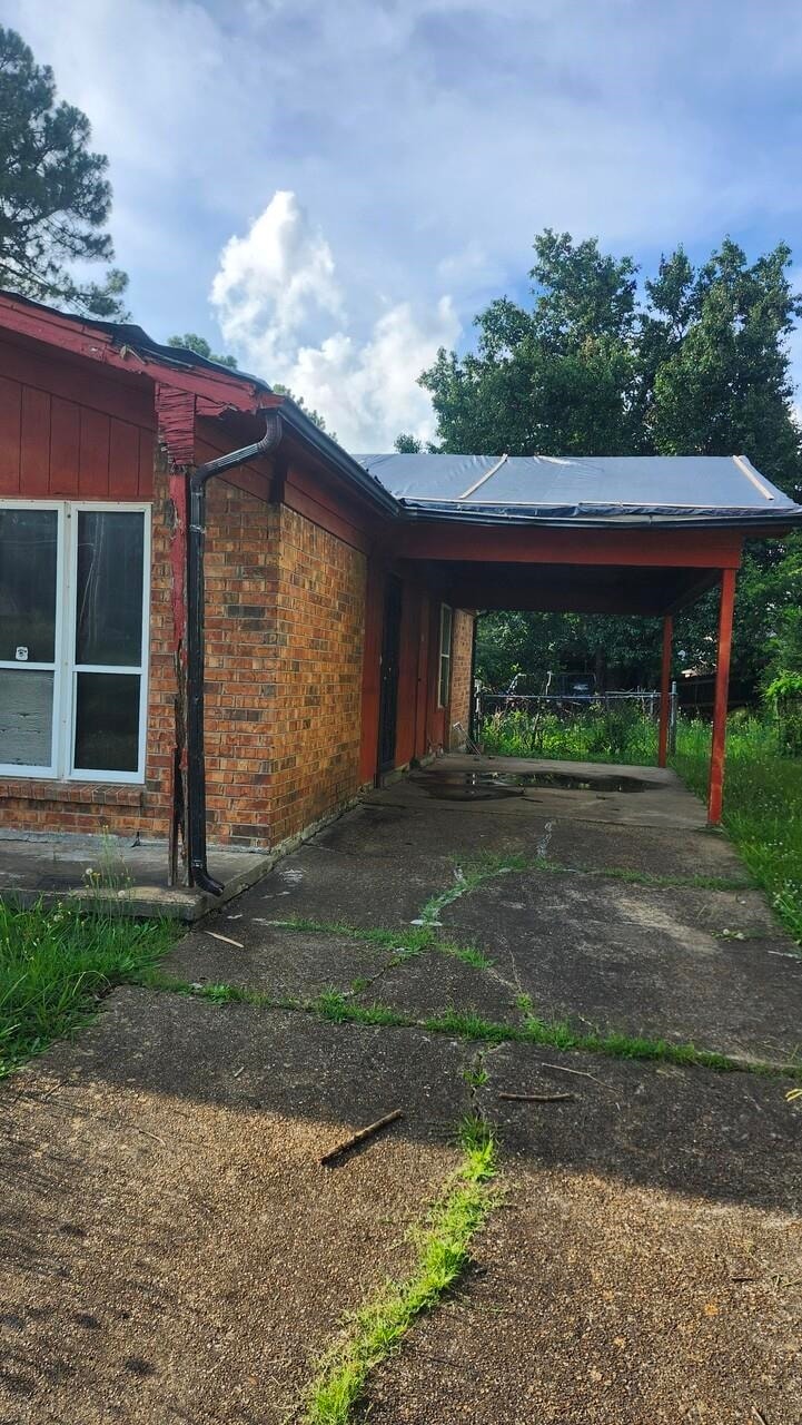 View of parking featuring driveway and a carport