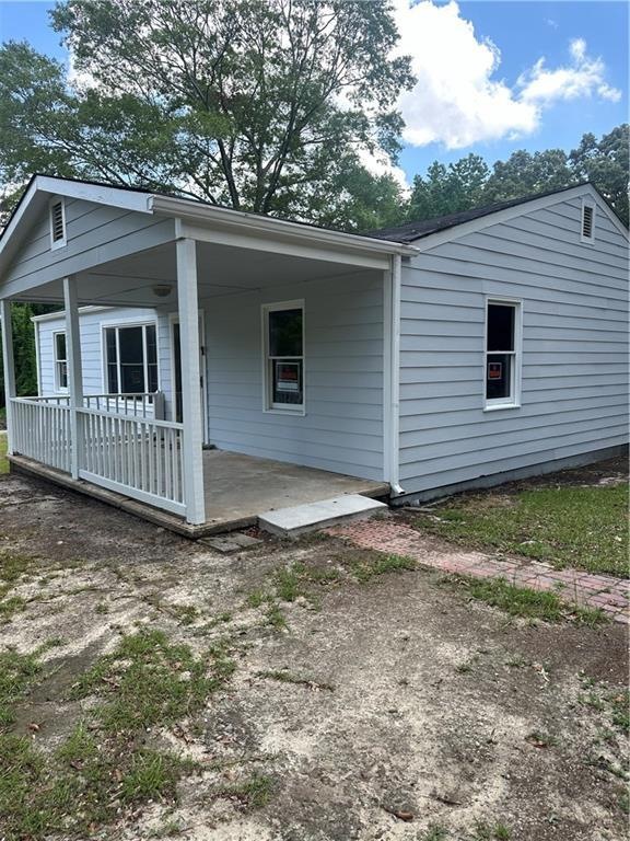 Back of property featuring covered porch