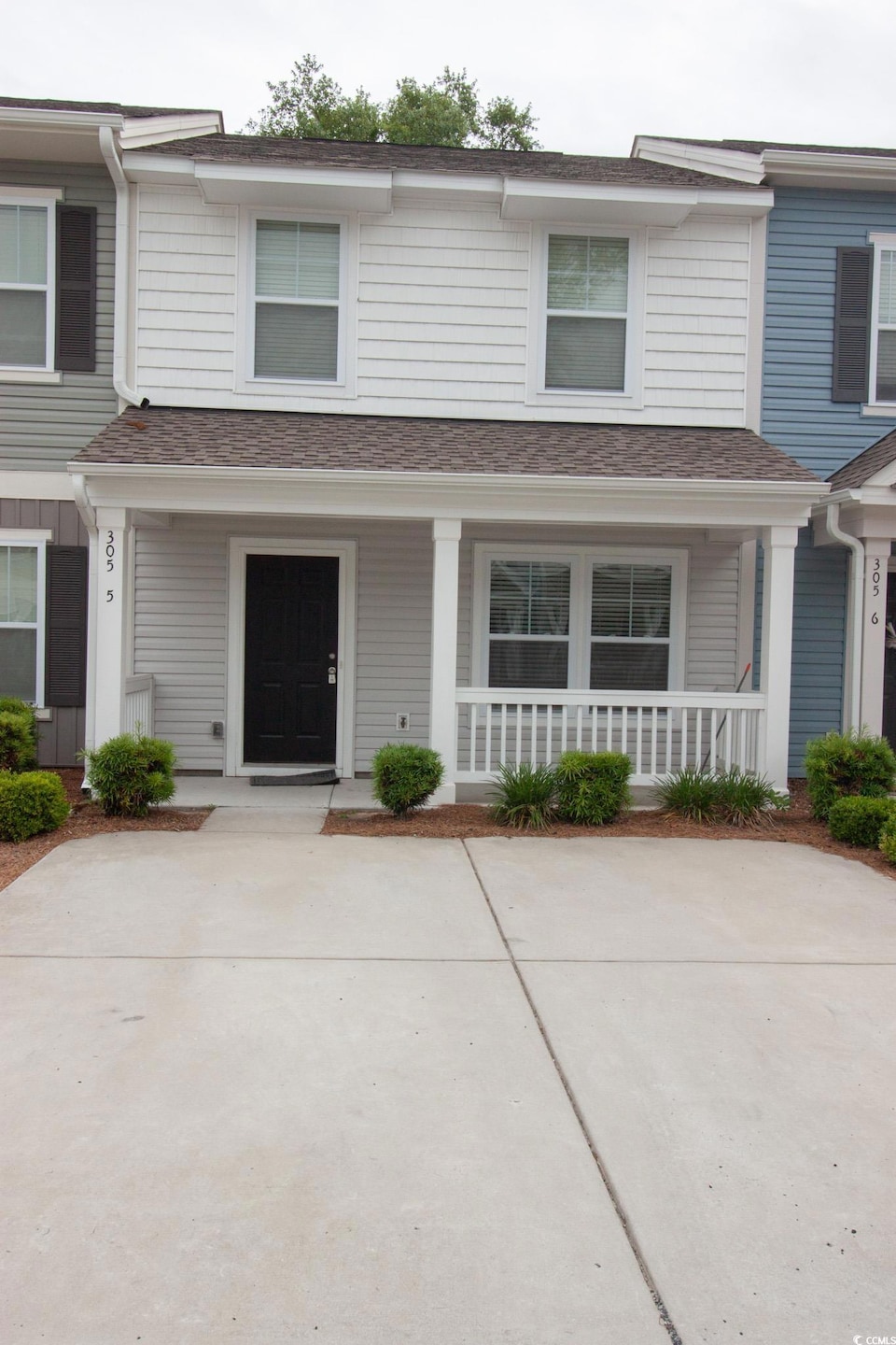 Multi unit property featuring covered porch and roof with shingles