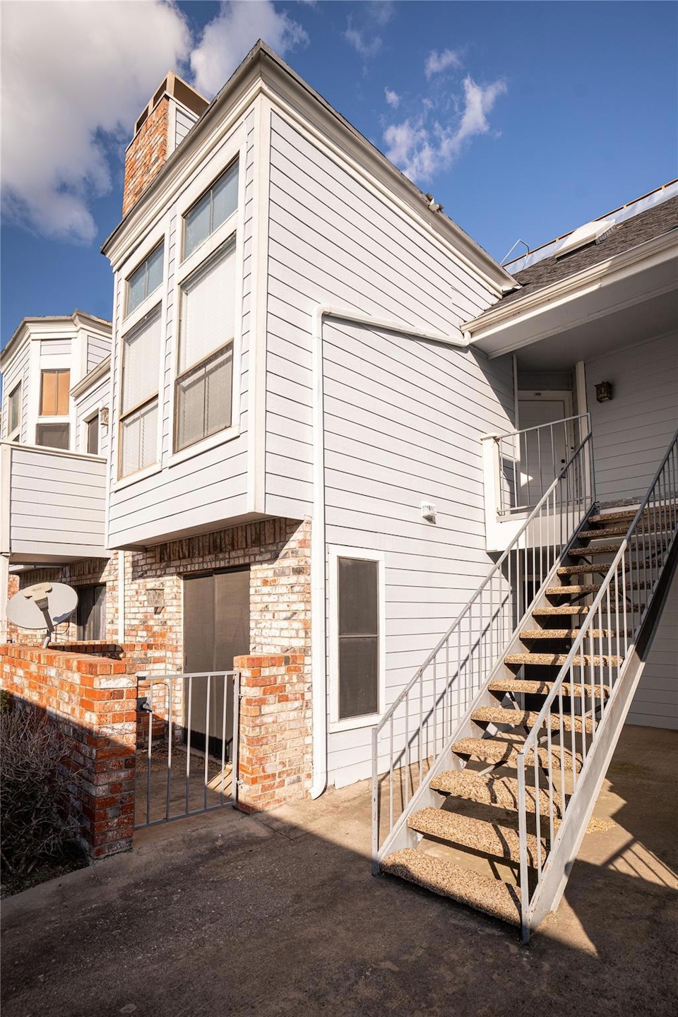 View of home's exterior featuring a chimney, stair