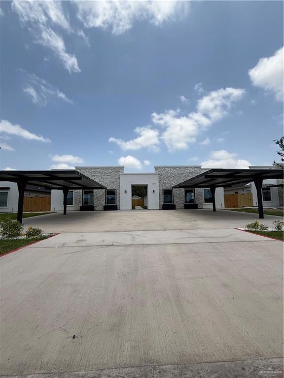 Front view of this modern four plex with a sleek stone facade and clean architectural lines.  Pretty green grass!
