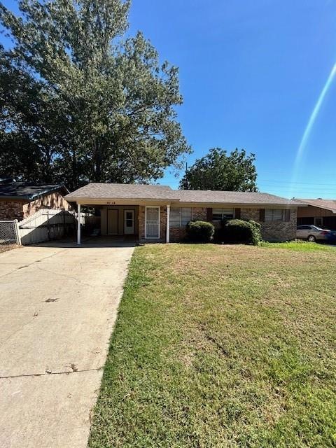 Single story home with a carport and a front yard