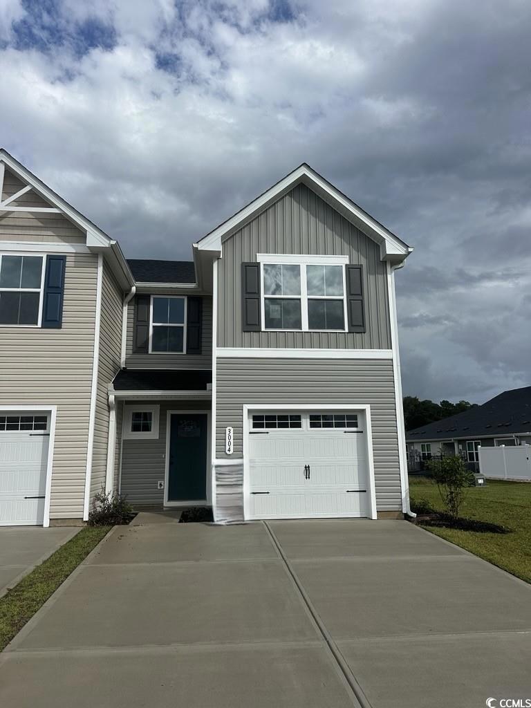 View of front of house featuring driveway, an attached garage, and board and batten siding