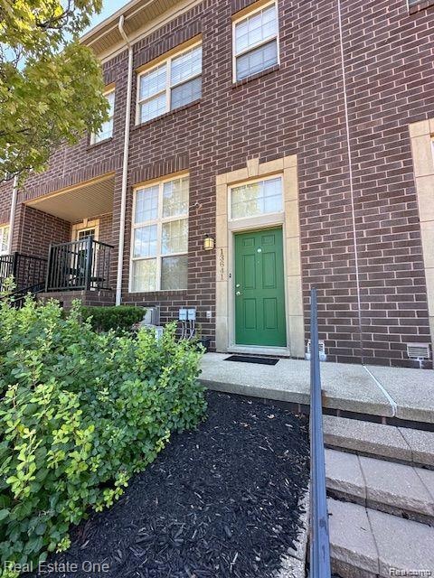 Doorway to property featuring brick siding