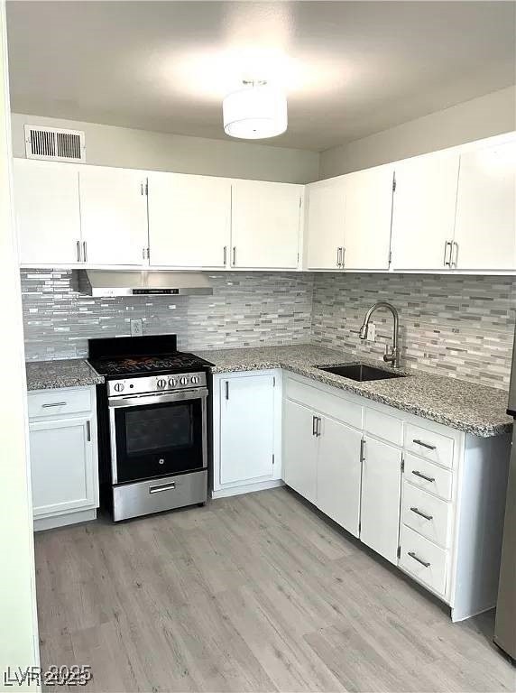 Kitchen featuring stainless steel range with gas s