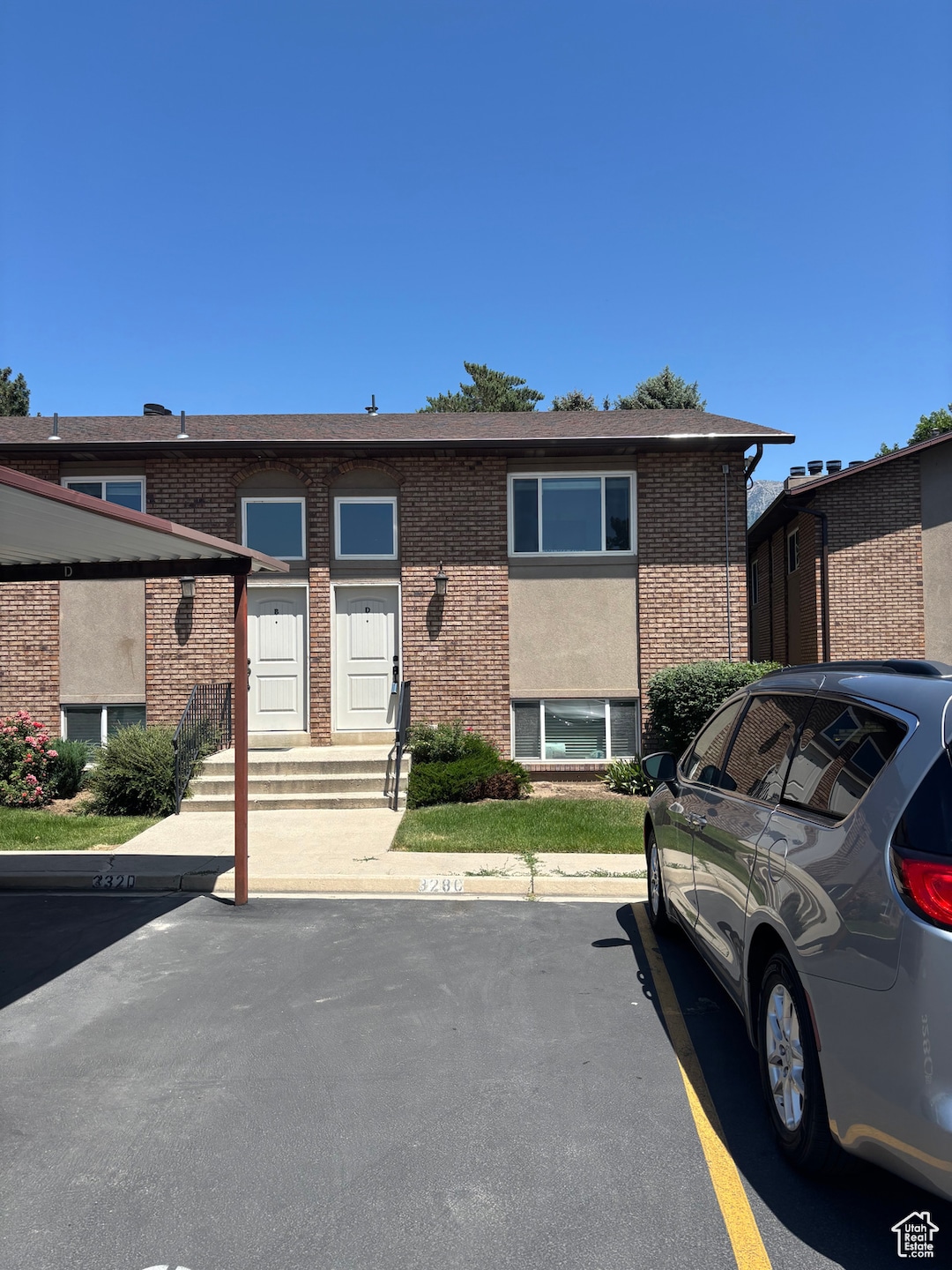 View of front of property featuring uncovered parking, brick siding, and entry steps