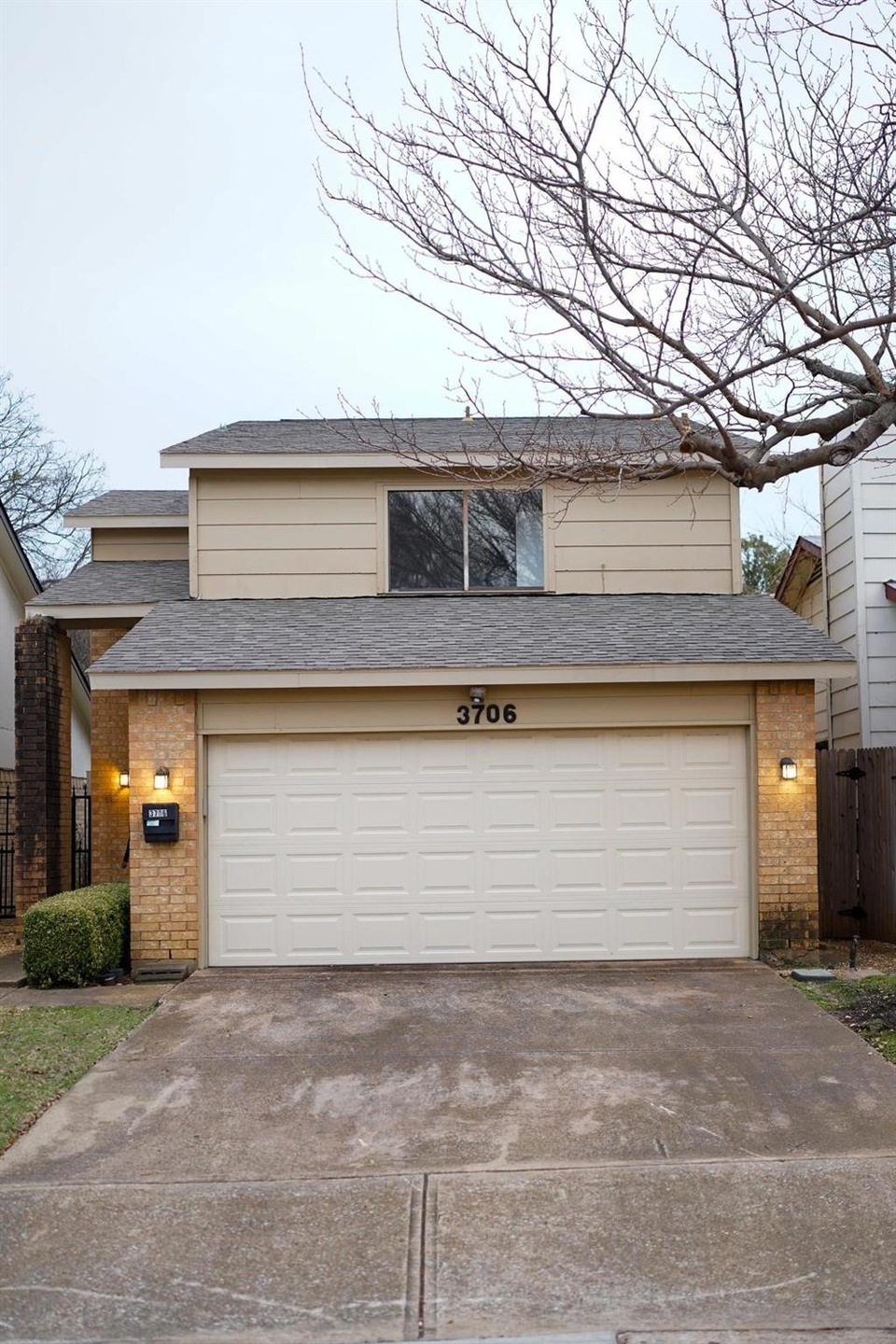 View of front facade with a garage, driveway, bric