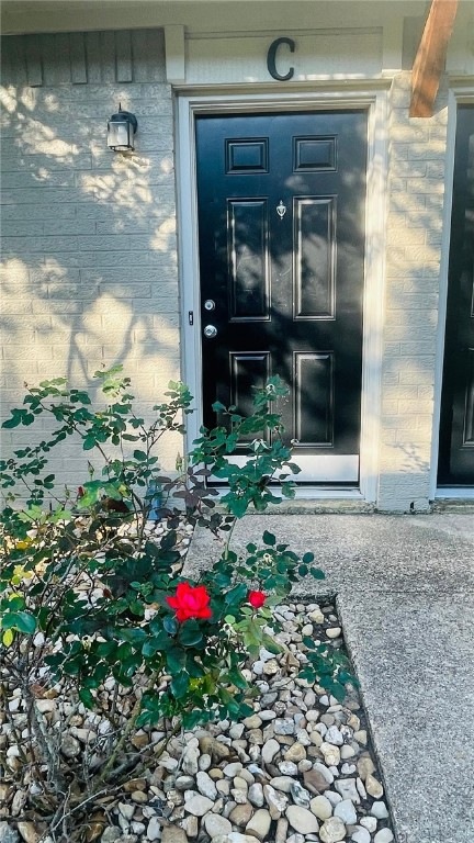 Property entrance featuring brick siding