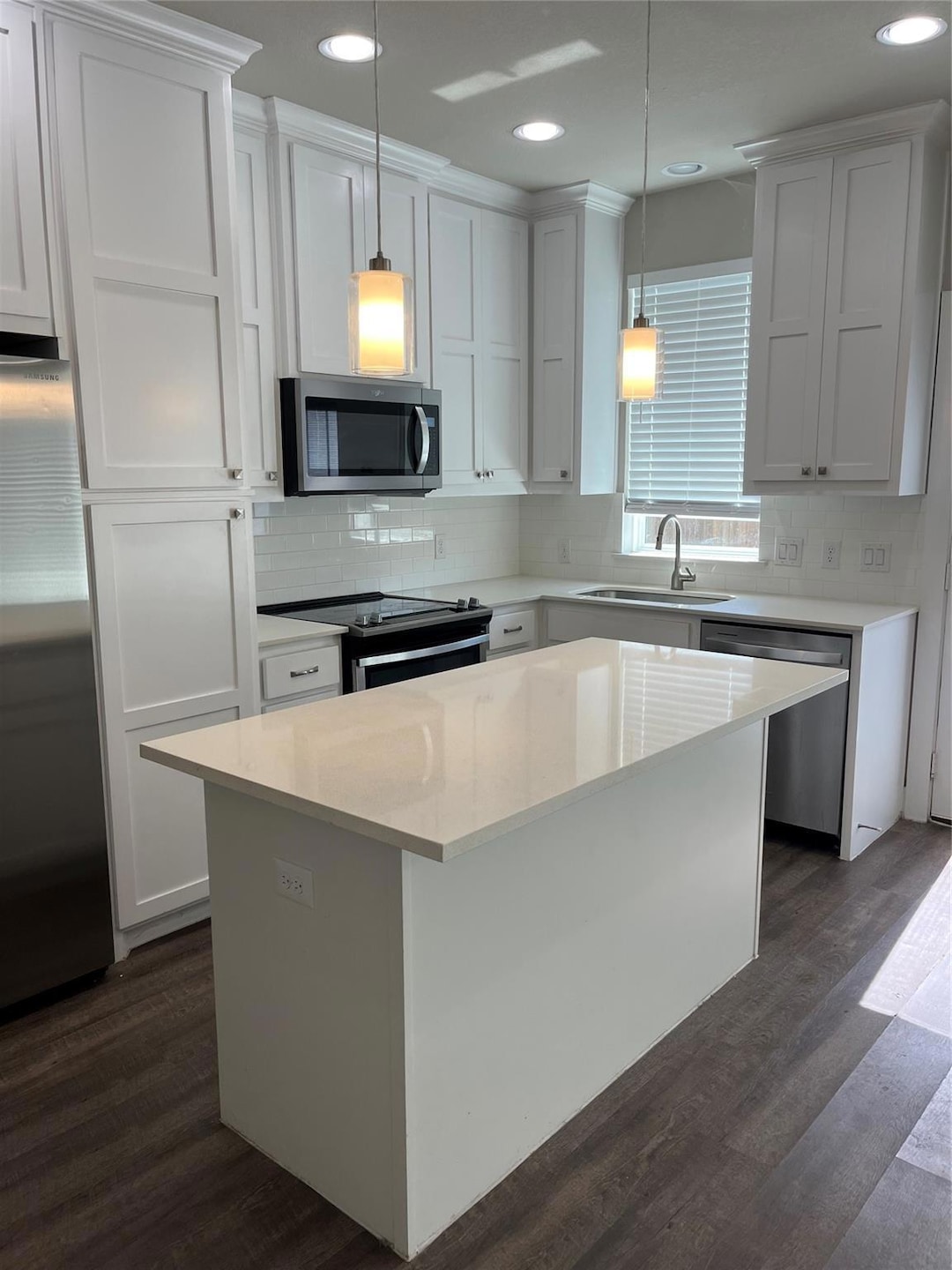 Kitchen with a sink, dark wood finished floors, fr