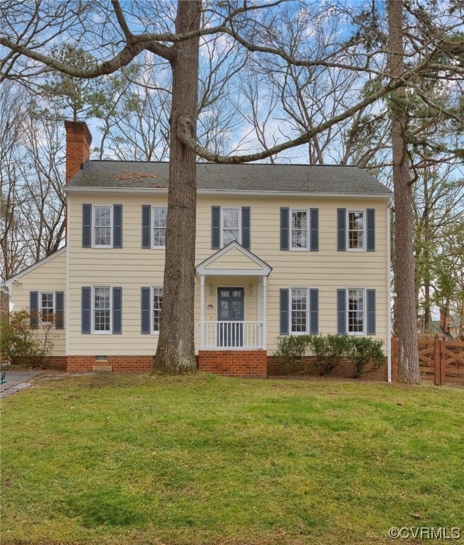 Colonial inspired home featuring a front lawn