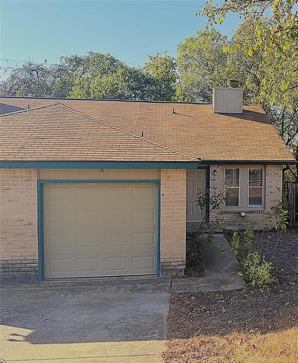 View of front of property featuring brick siding and a shingled roof