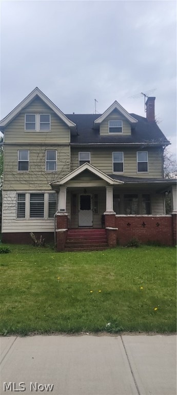 Front of property with covered porch and a front yard