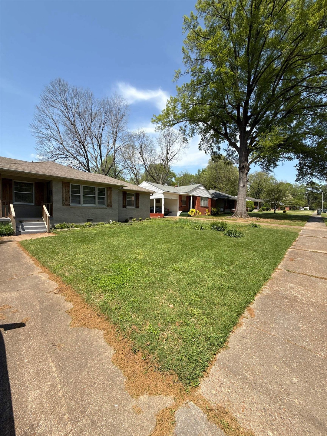 Single story home with a porch and a front yard